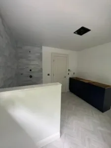 Clean bathroom layout featuring new tile and vanity, ready for final painting touches.