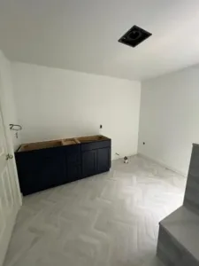 Bathroom repainting underway with white walls and dark vanity awaiting final fixtures.