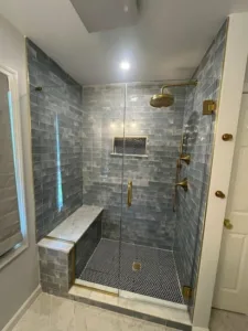 Elegant shower with glass doors, custom tile work, and built-in bench showcasing a Full Bathroom Remodel.