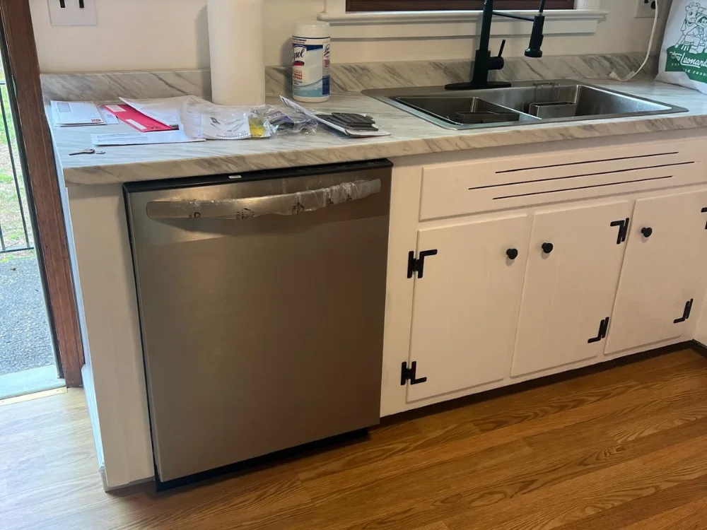 Dishwasher installation showing appliance fitted under kitchen counter