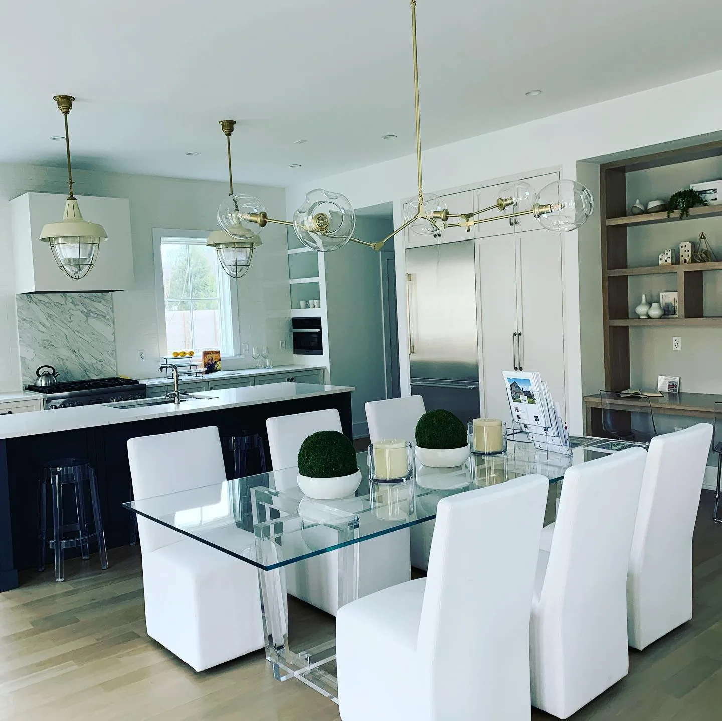 Modern kitchen and dining area showcasing fresh Fairfield County interior painting, with white walls contrasting a dark island and wood floors.