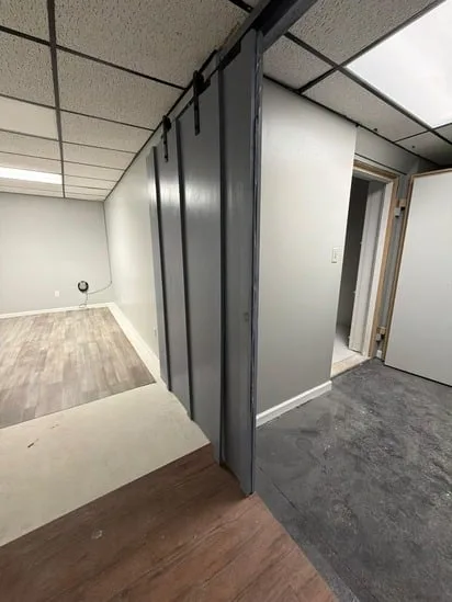Interior floor and paint update in a room featuring fresh grey walls and new laminate flooring.